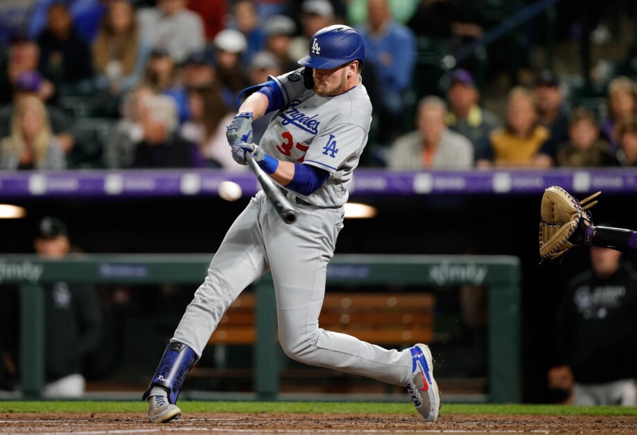 Los Angeles Dodgers' Gavin Lux, left, trips over Colorado Rockies