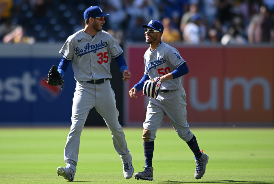 Los Angeles Dodgers right fielder Mookie Betts, left, talks with center  fielder Cody Bellinger, right, after Bellinger caught the ball in front of  him during a baseball game against the Philadelphia Phillies